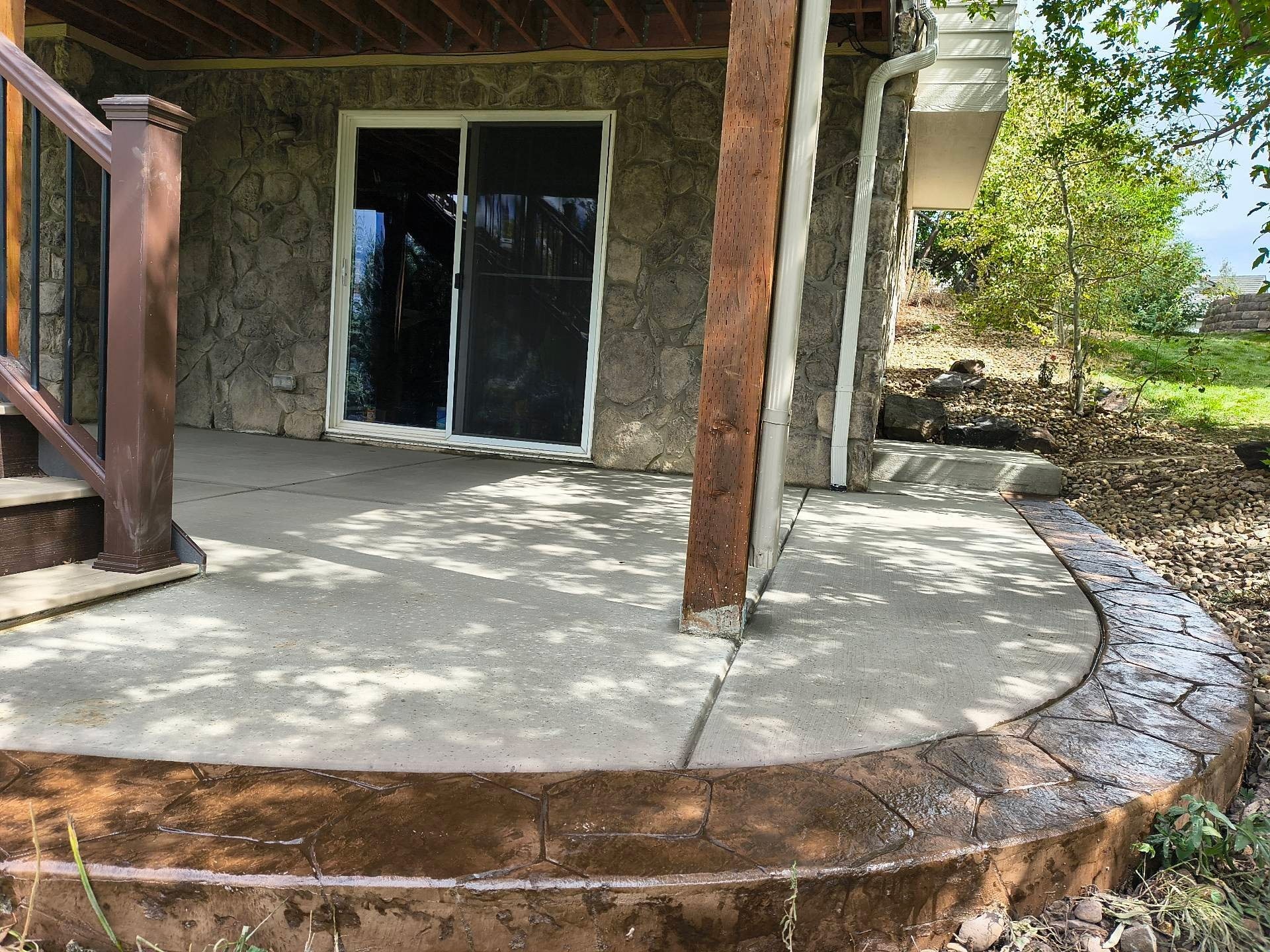Concrete Patio with Stone House Exterior — Yardage Outdoor Living